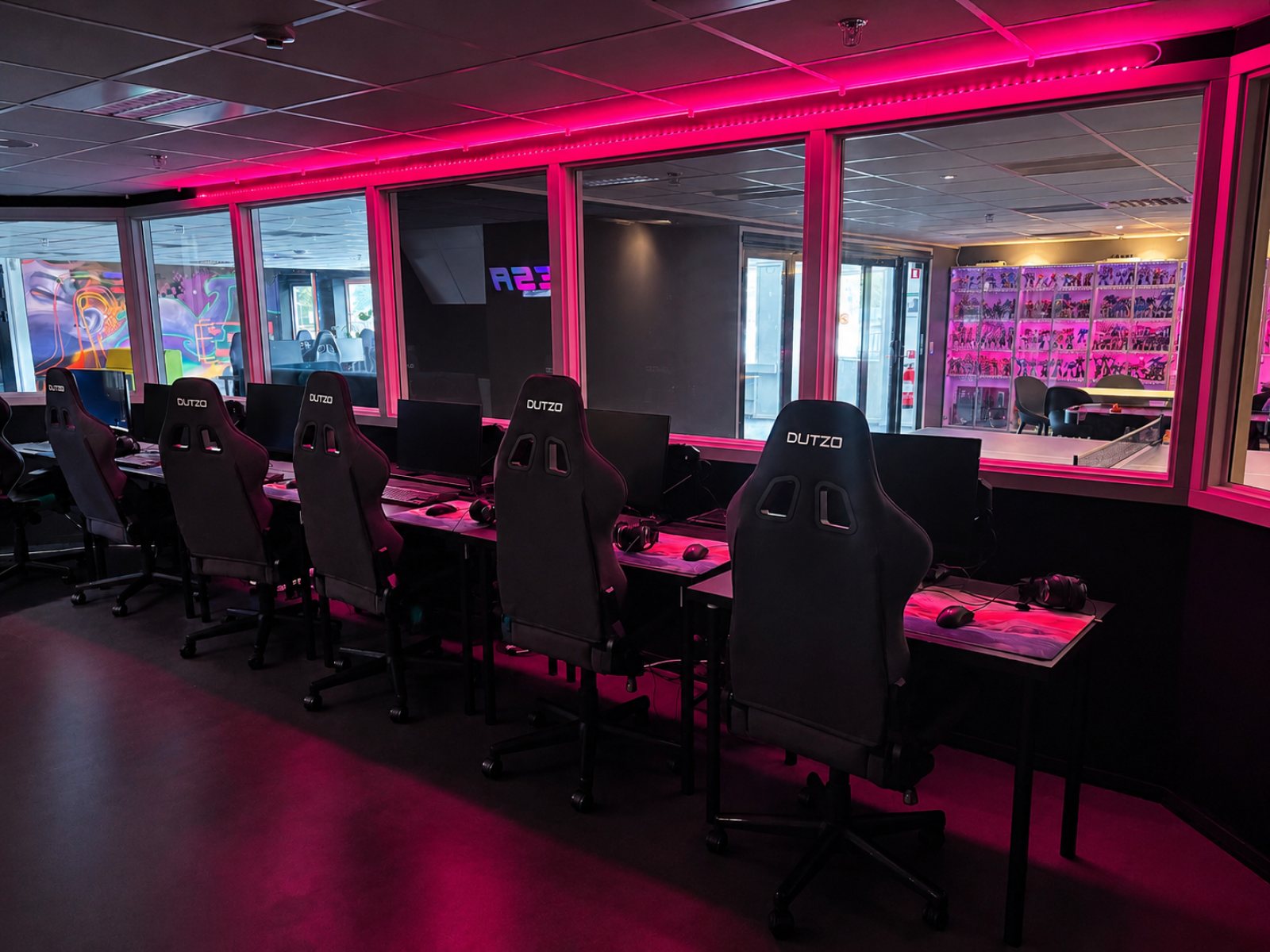 E-Sports Academys gamingcenter med rosa LED-belysning och gamingplatser
