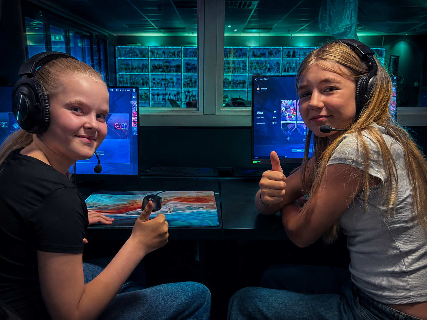 Två deltagare med headset sitter vid datorer i E-Sports Academys lokal